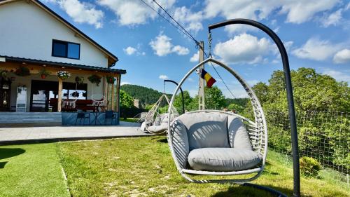 two swinging chairs in the yard of a house at Cabana Brad Apuseni in Rîmeţi