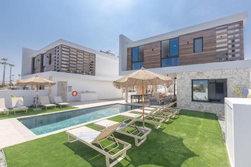 a villa with a swimming pool and lawnitures at Orea Luxury Villas in Ayia Napa