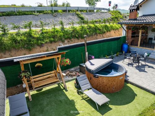 a small backyard with a hot tub and chairs at Cabana Brad Apuseni in Rîmeţi