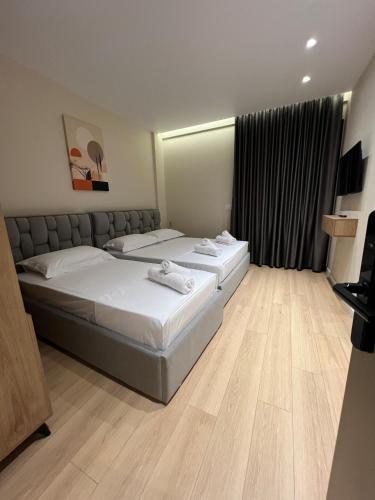 a hotel room with two beds and a window at Vila Serenita in Vlorë