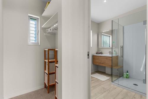 a bathroom with a glass shower and a sink at Seaview - Mangawhai Heads Holiday Home in Mangawhai
