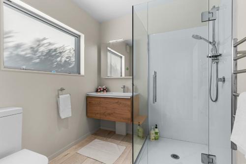 a bathroom with a shower and a sink at Seaview - Mangawhai Heads Holiday Home in Mangawhai