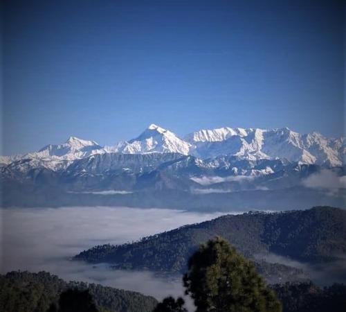 a view of a mountain range with snow covered mountains at Himvadi Resorts Kausani in Kausani
