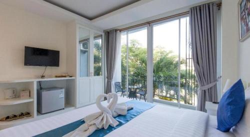 a bedroom with a large bed with swans on it at Evergreen Resort Cha-am in Cha Am