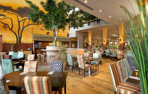 un restaurante con mesas y sillas y un bar en Chessington Hotel en Chessington