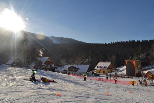 a group of people skiing down a snow covered slope at Penzion Rotunda in Harrachov