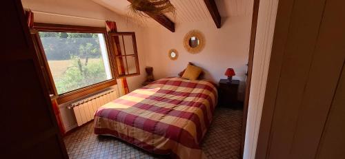 a small bedroom with a bed and a window at Maison Provençale avec piscine in Estoublon