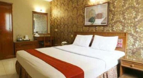 a bedroom with a large white bed in a room at Hotel Permata Bandara in Jakarta