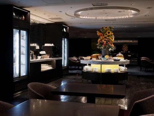 a restaurant with tables and chairs and a flower arrangement at Sapporo Grand Hotel in Sapporo
