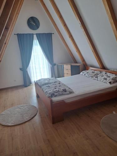 a bedroom with a bed and a window with rugs at Vikendica Una-Bakšaiš in Bihać