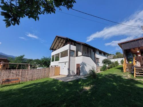a white house with a black roof at Casa David in Gura Hangului
