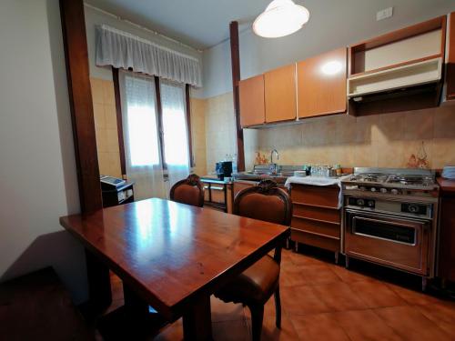 a kitchen with a wooden table and a wooden table and chairs at Bocasa affittacamere 