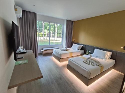 a hotel room with two beds and a window at Supalai Pasak Resort Hotel And Spa in Kaeng Khoi