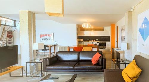 a living room with a leather couch and a kitchen at Casa Cotera in Sierra