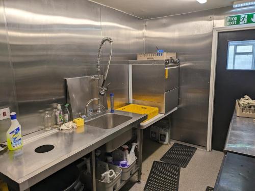 a kitchen with a sink and a counter top at Lake District Pub with 10 en-suite rooms in Hawkshead