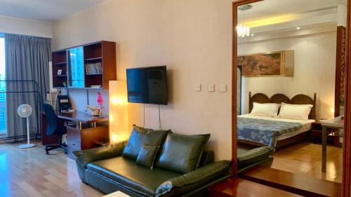 a bedroom with a couch and a bed and a mirror at Beijing city center - Cosy family suite with city view in Beijing
