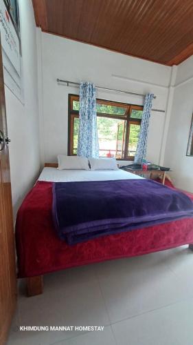 a large bed in a room with a window at Khimdung Mannat Homestay in Mangpu