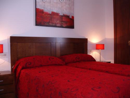 1 dormitorio con 1 cama con colcha roja en Coblanca 8 - Zand Properties, en Benidorm