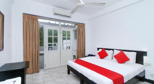 a bedroom with a large bed with red pillows at Nathaliya Transit Hotel in Seeduwa