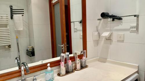 a bathroom sink with toothbrushes and a mirror at Beijing city center - Cosy family suite with city view in Beijing