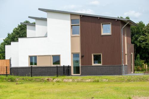 a house with a brown and white facade at Kooparc vakantiepark in Giesbeek