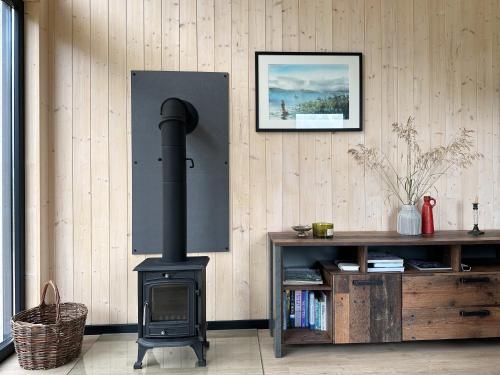 a wood stove in a room with a book shelf at Lake Garden Villa in Sadžiūnai
