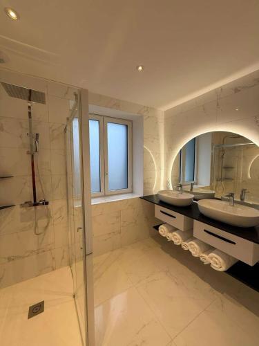 a large bathroom with two sinks and a shower at Au coeur du chaos in Huelgoat