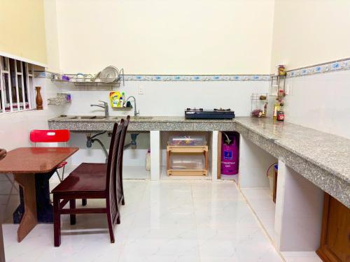 a kitchen with a counter and a table with a chair at HAPPY TEA Motel in Long Hai