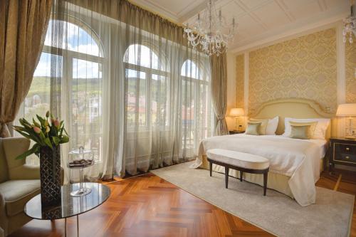 - une chambre avec un grand lit et un lustre dans l'établissement Amadria Park Hotel Milenij, à Opatija