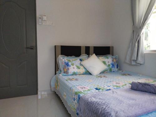 a bedroom with a bed with pillows and a window at MYDY Angsana Homestay in Alor Setar