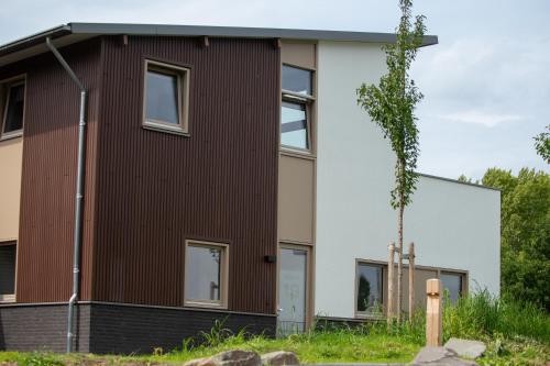 a house with a brown and white facade at Kooparc vakantiepark in Giesbeek