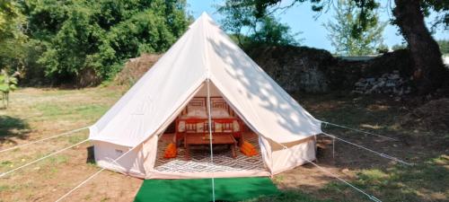 a white tent with a bed in a field at tente india in Le Pener