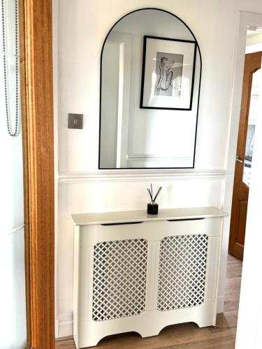 a white console table in a hallway with a mirror at Newtown Hideaway in Boʼness