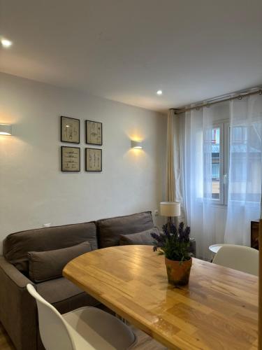 a living room with a couch and a wooden table at Dolsa, acogedor refugio al Pas de la Casa in Andorra la Vella