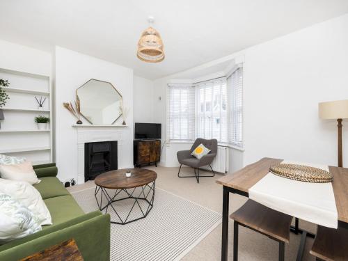 a living room with a green couch and a table at Pass the Keys Poets' Corner Stylish Apartment Station Location in Brighton & Hove