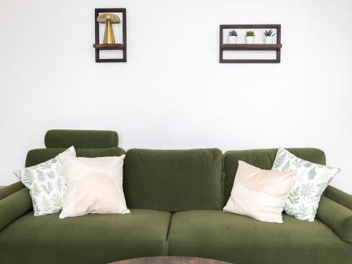 a green couch with pillows on it in a room at Pass the Keys Poets' Corner Stylish Apartment Station Location in Brighton & Hove