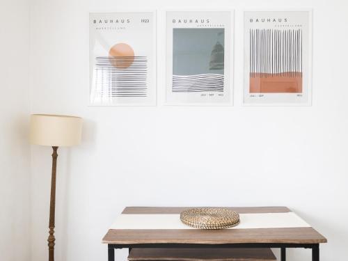 a table with a lamp and posters on the wall at Pass the Keys Poets' Corner Stylish Apartment Station Location in Brighton & Hove