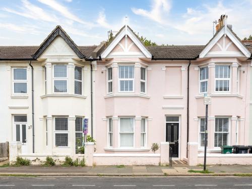 a large pink house on the side of a street at Pass the Keys Poets' Corner Stylish Apartment Station Location in Brighton & Hove