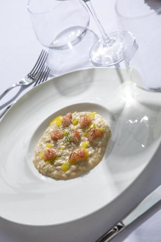 a white plate with a dish of food on a table at Cortona Resort-Le Terre Dei Cavalieri in Cortona