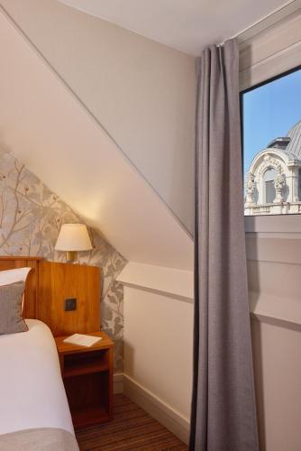 a bedroom with a bed and a window at Timhotel Le Louvre in Paris