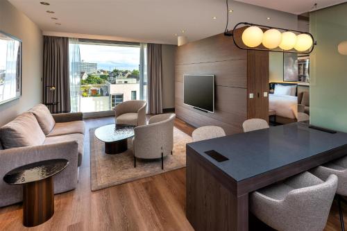 a living room with a couch and a table at Radisson Blu Media Harbour Hotel, Düsseldorf in Düsseldorf