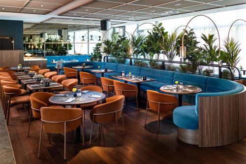 a row of tables and chairs in a restaurant at Radisson Blu Media Harbour Hotel, Düsseldorf in Düsseldorf