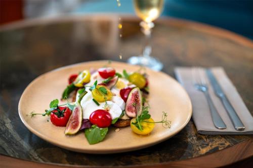 a plate of food with fruit and vegetables on a table at Radisson Blu Media Harbour Hotel, Düsseldorf in Düsseldorf