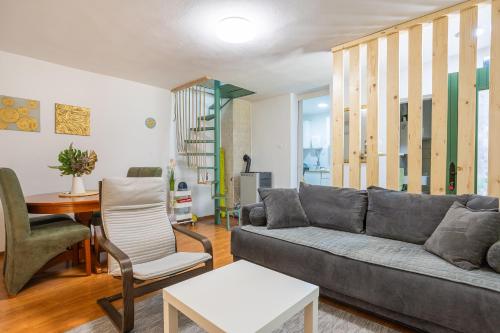 a living room with a gray couch and chairs at Vikendica WoodNook Kosmaj - Šumski kutak in Sopot