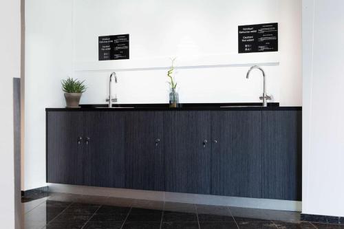 a kitchen with two sinks and two faucets at Scandic Helsinki Aviapolis in Vantaa