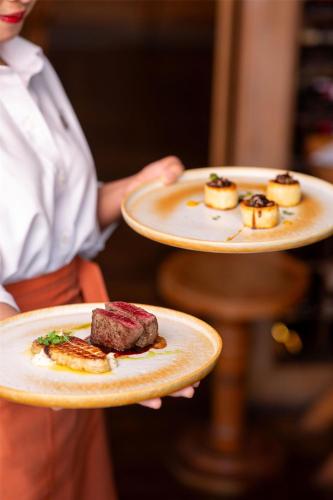 a person holding two plates with food on them at Radisson Blu Plaza Bangkok in Bangkok