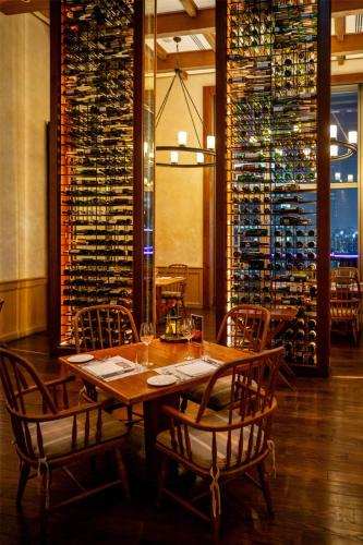 a dining room with a table and chairs and wine racks at Radisson Blu Plaza Bangkok in Bangkok