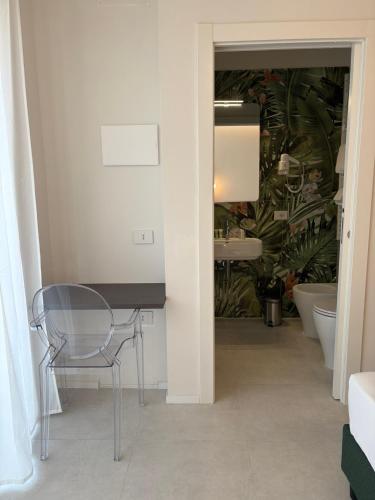 a table and a chair in a room with a bathroom at Ruffini Boutique Rooms in Ascoli Piceno
