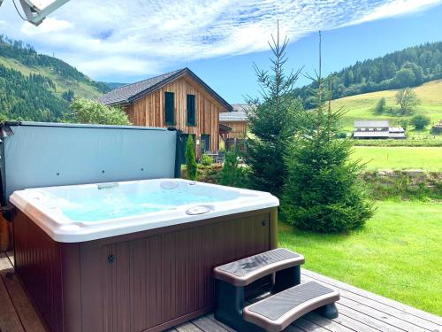 a hot tub sitting on a deck in a yard at Chalet Murau: Luxurious 5 star chalet in ski area Kreischberg in Murau