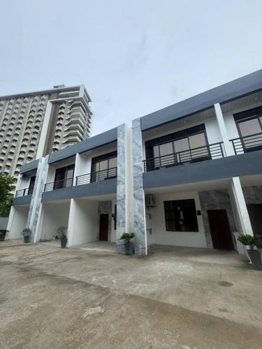 a large white building with a parking lot at Casa Noah in Maribago